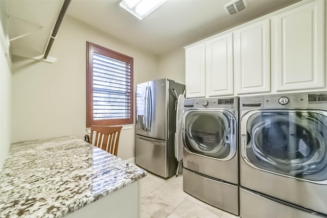 laundry room featuring independent washer and dryer, cabinet space, and visible vents