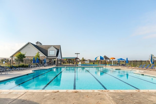 pool with a patio area and fence