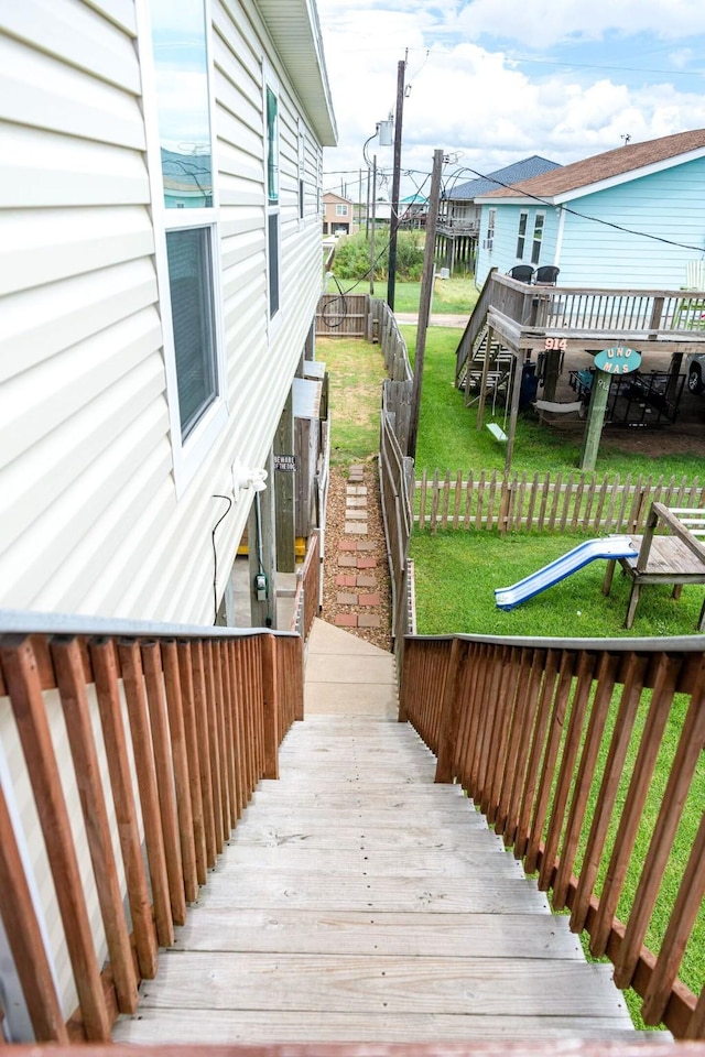 wooden terrace with a yard and fence