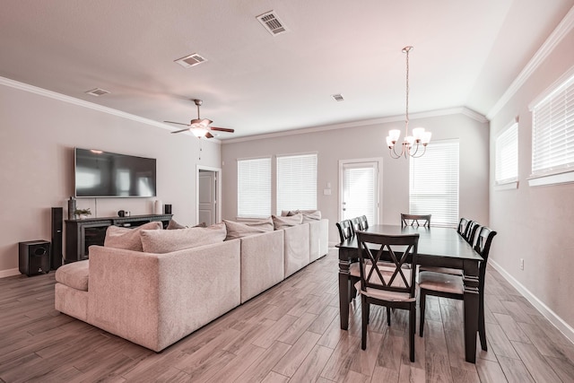 interior space with plenty of natural light, visible vents, wood finished floors, and ornamental molding