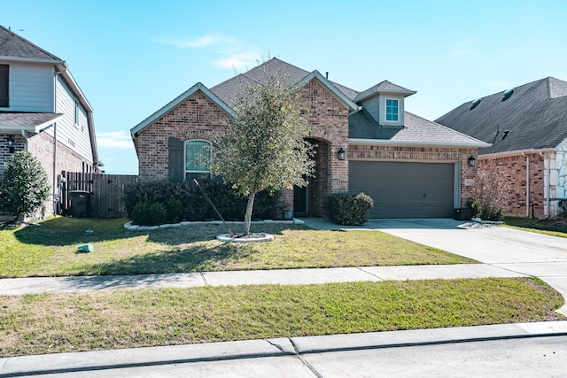 view of front of home with brick siding, a shingled roof, an attached garage, driveway, and a front lawn