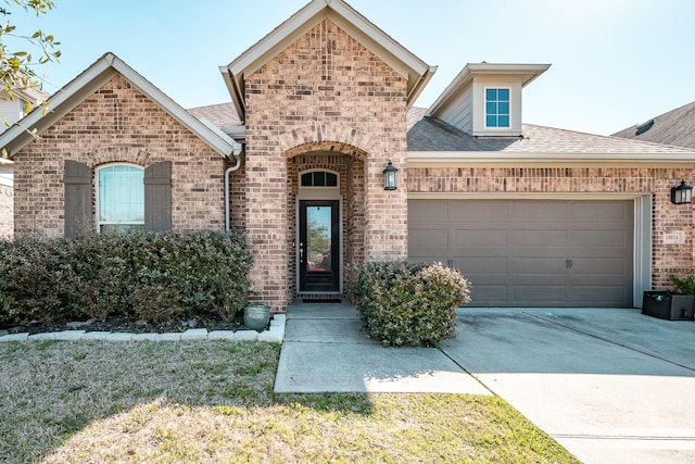 french provincial home featuring driveway, an attached garage, a shingled roof, and brick siding