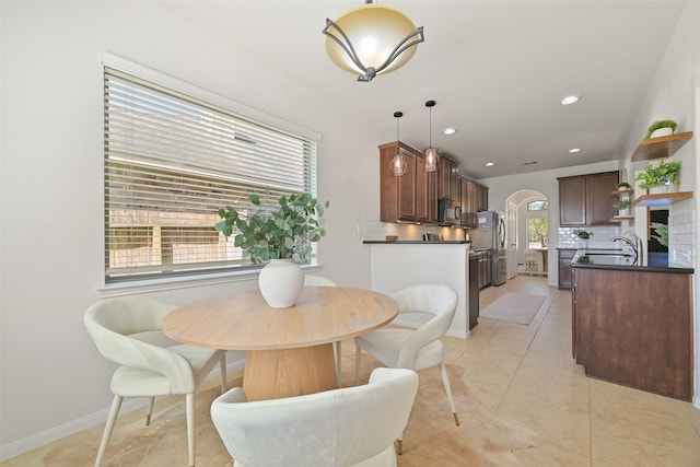 dining space featuring recessed lighting, arched walkways, and baseboards