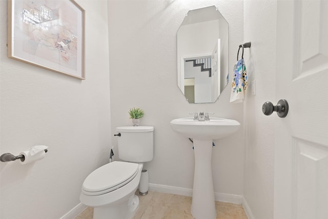 bathroom with toilet and baseboards