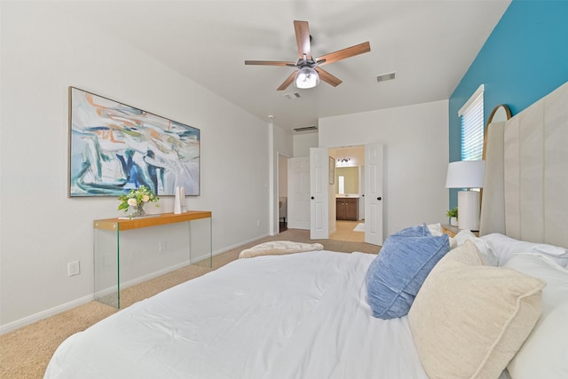 carpeted bedroom with a ceiling fan, ensuite bath, baseboards, and visible vents