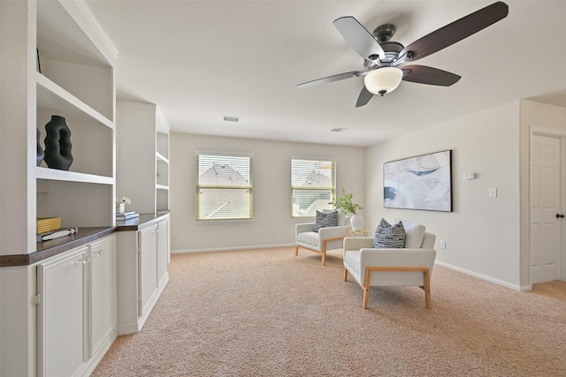 living area featuring light carpet, visible vents, ceiling fan, and baseboards