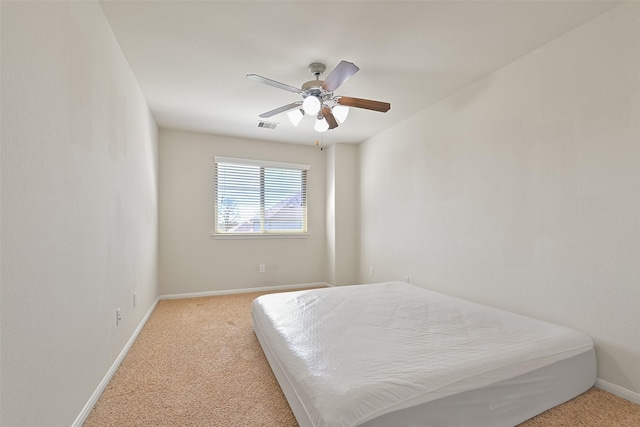 carpeted bedroom featuring visible vents, baseboards, and a ceiling fan