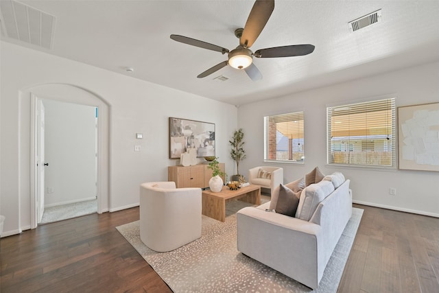 living area with visible vents, baseboards, and dark wood-type flooring