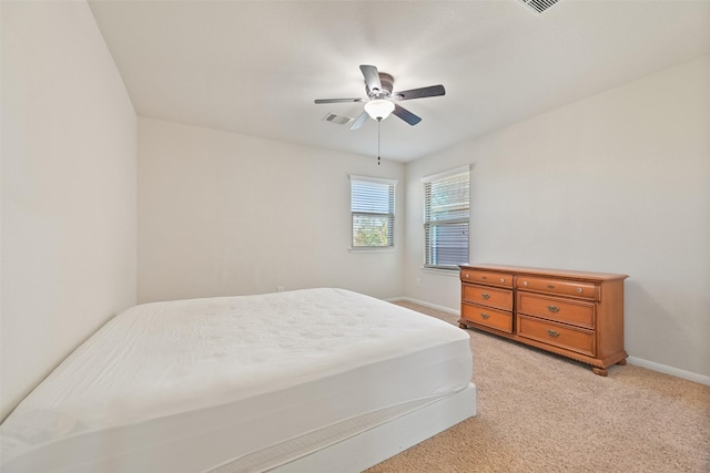 bedroom featuring visible vents, baseboards, light colored carpet, and a ceiling fan