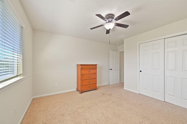 unfurnished bedroom featuring carpet, visible vents, baseboards, ceiling fan, and a closet