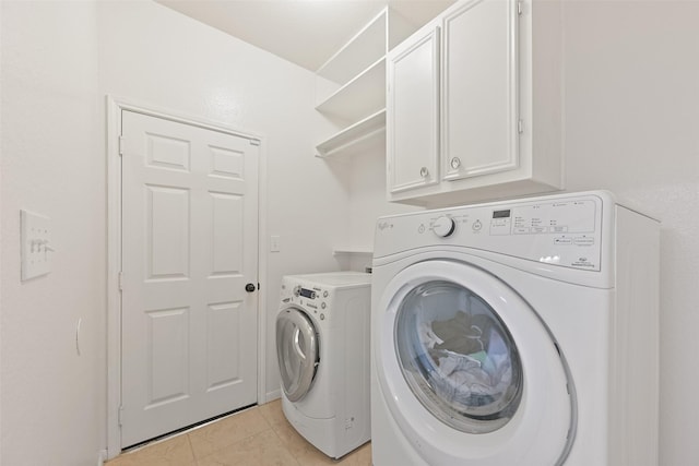 laundry area with light tile patterned floors, cabinet space, and independent washer and dryer