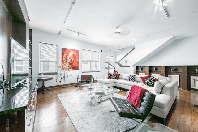 living area featuring rail lighting, visible vents, baseboards, and wood finished floors