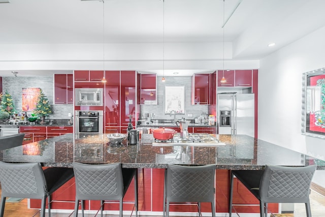 kitchen featuring red cabinetry, stainless steel appliances, dark brown cabinets, backsplash, and modern cabinets