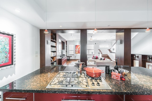 kitchen with stainless steel gas cooktop, hanging light fixtures, and open floor plan