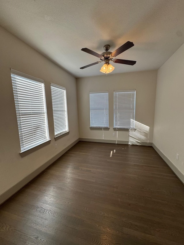 spare room featuring a textured ceiling, ceiling fan, wood finished floors, and baseboards