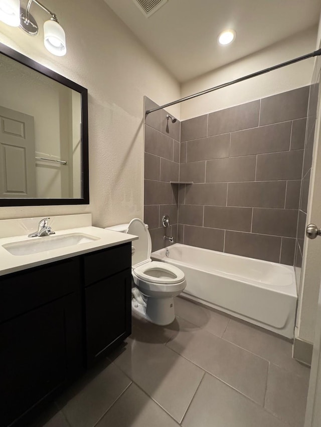 bathroom with bathtub / shower combination, toilet, visible vents, vanity, and tile patterned floors