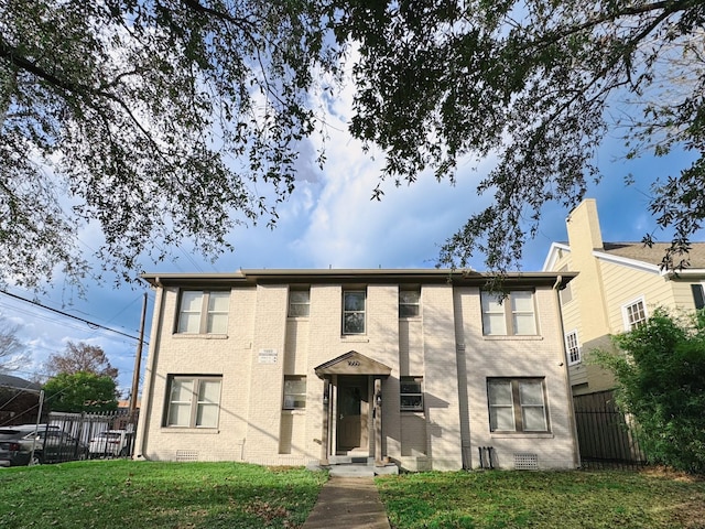 multi unit property with brick siding, crawl space, a front lawn, and fence