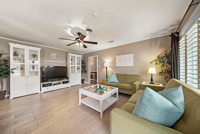 living room featuring ceiling fan, crown molding, visible vents, and light wood-style floors