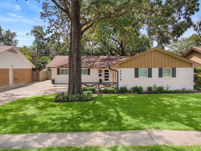 single story home with brick siding, fence, and a front lawn