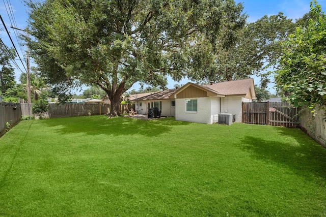 view of yard featuring a fenced backyard and central air condition unit