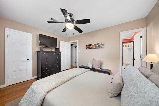 bedroom with baseboards, visible vents, dark wood finished floors, and a ceiling fan