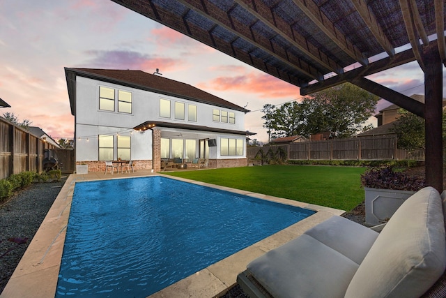 view of swimming pool featuring a fenced backyard, an outdoor living space, a lawn, a fenced in pool, and a patio area