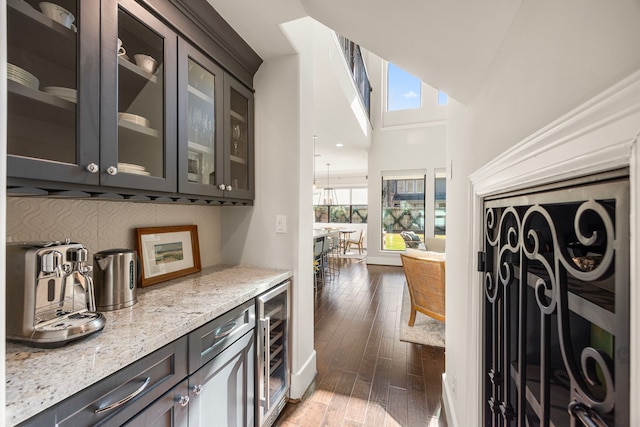 bar featuring beverage cooler, dark wood-type flooring, plenty of natural light, and decorative backsplash