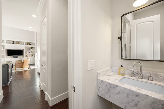 bathroom featuring hardwood / wood-style flooring, baseboards, a sink, and recessed lighting