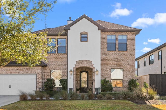 view of front of house featuring brick siding, concrete driveway, an attached garage, fence, and stucco siding