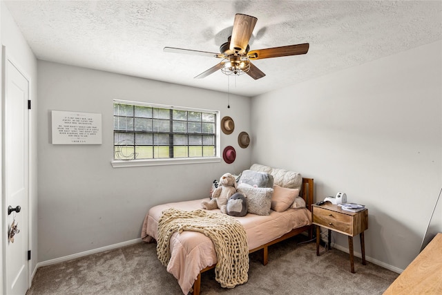 carpeted bedroom featuring a ceiling fan, baseboards, and a textured ceiling