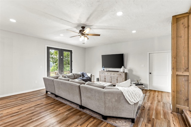 living room with recessed lighting, wood finished floors, and french doors