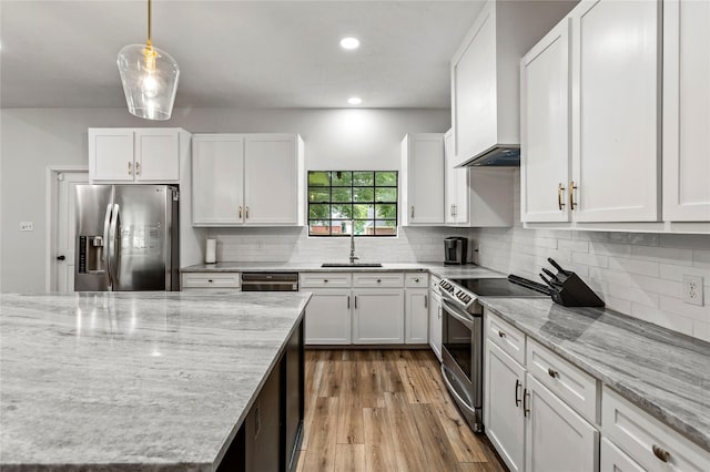 kitchen featuring appliances with stainless steel finishes, a sink, and white cabinetry