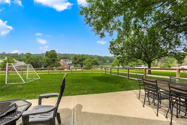 surrounding community featuring a rural view, fence, and a patio