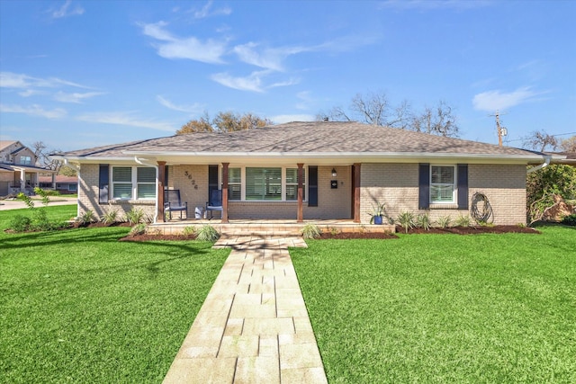 ranch-style home with covered porch, roof with shingles, brick siding, and a front lawn