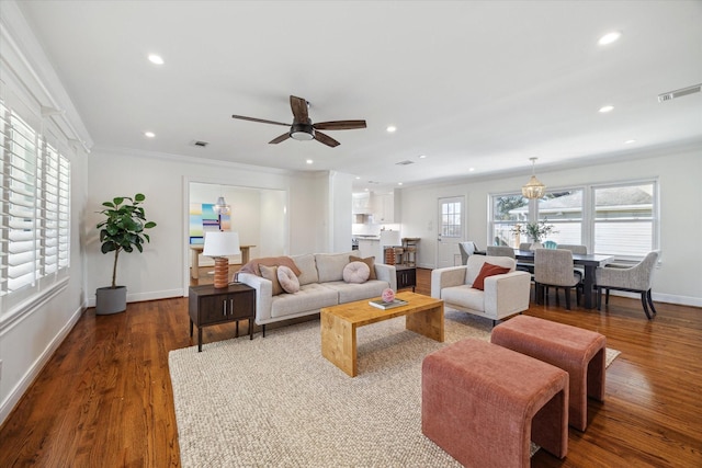 living room with visible vents, ornamental molding, ceiling fan, and wood finished floors