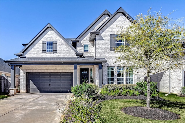 french country home with brick siding, driveway, and a garage