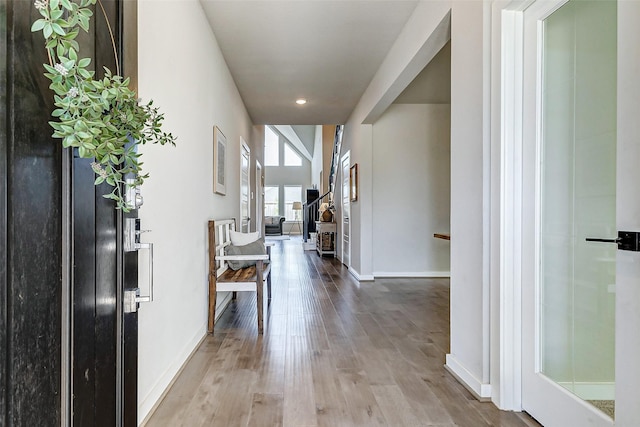 corridor with baseboards and wood finished floors