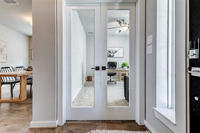 doorway to outside featuring ceiling fan, visible vents, and wood finished floors