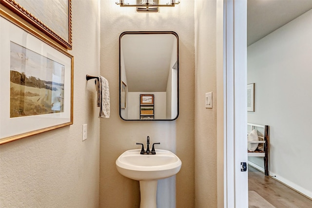 bathroom featuring wood finished floors and baseboards