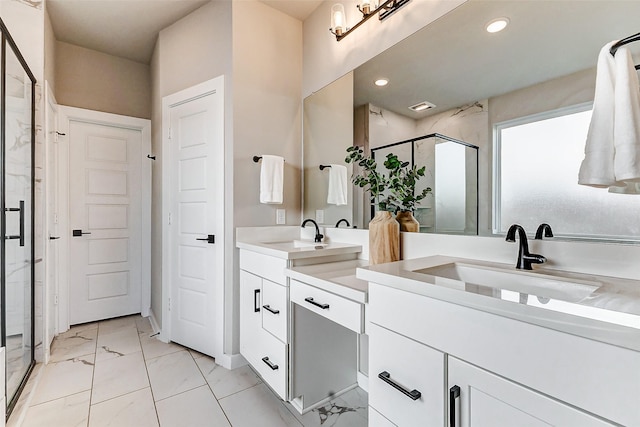 full bath featuring a shower stall, double vanity, marble finish floor, and a sink