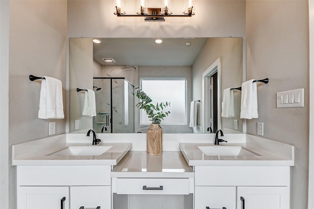 bathroom featuring a sink, two vanities, and a stall shower