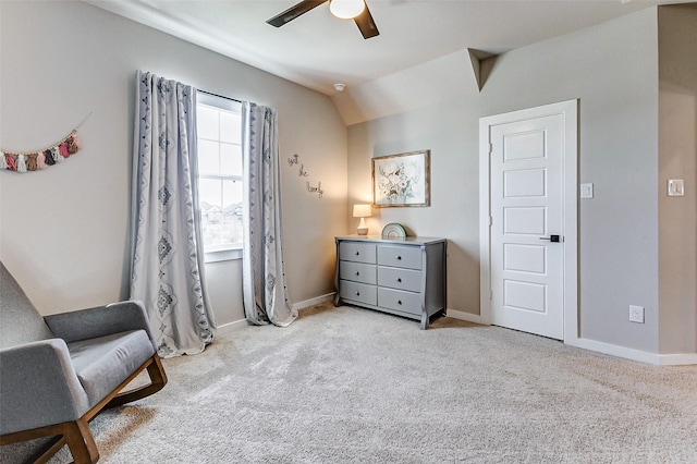 sitting room with a ceiling fan, lofted ceiling, light colored carpet, and baseboards