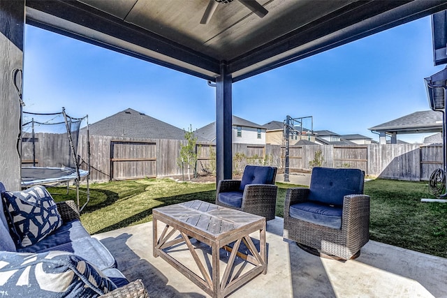 view of patio / terrace featuring a trampoline, a fenced backyard, and a ceiling fan