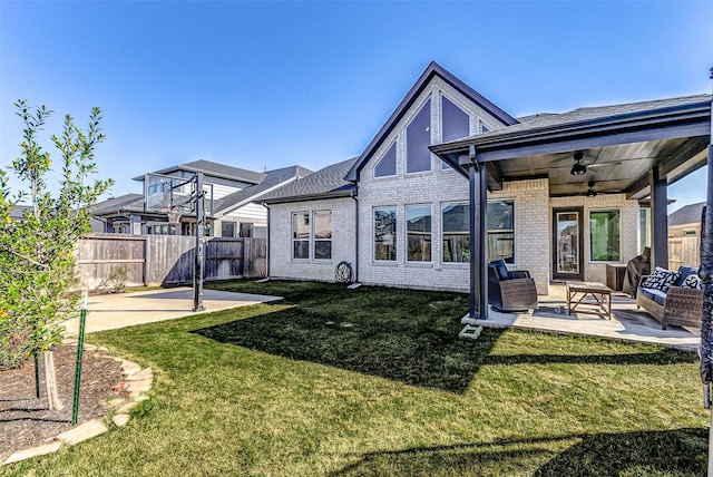 rear view of property featuring a ceiling fan, fence, a yard, brick siding, and a patio area