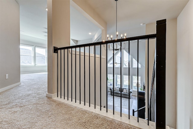 interior space featuring carpet flooring, baseboards, and a chandelier