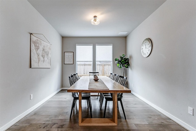 dining area with visible vents, baseboards, and wood finished floors