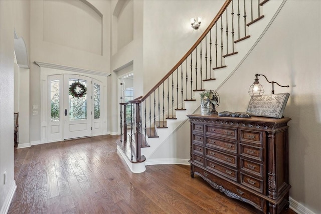 foyer with dark wood-style floors, a high ceiling, stairway, and baseboards