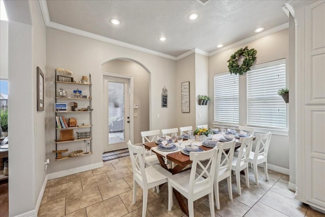 dining area featuring arched walkways, ornamental molding, recessed lighting, and baseboards