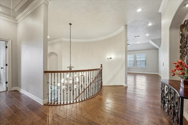 hall with hardwood / wood-style floors, attic access, and crown molding