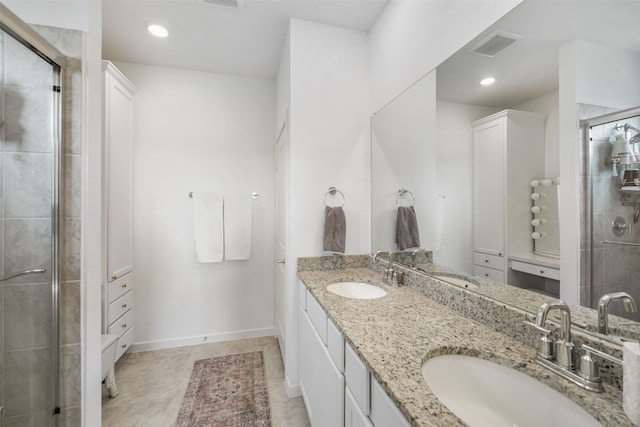 full bathroom featuring double vanity, a stall shower, a sink, and visible vents